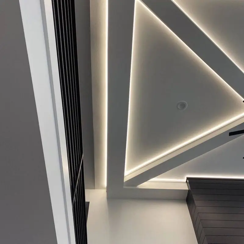 A triangular coffered ceiling with LED cove lighting tucked into each step