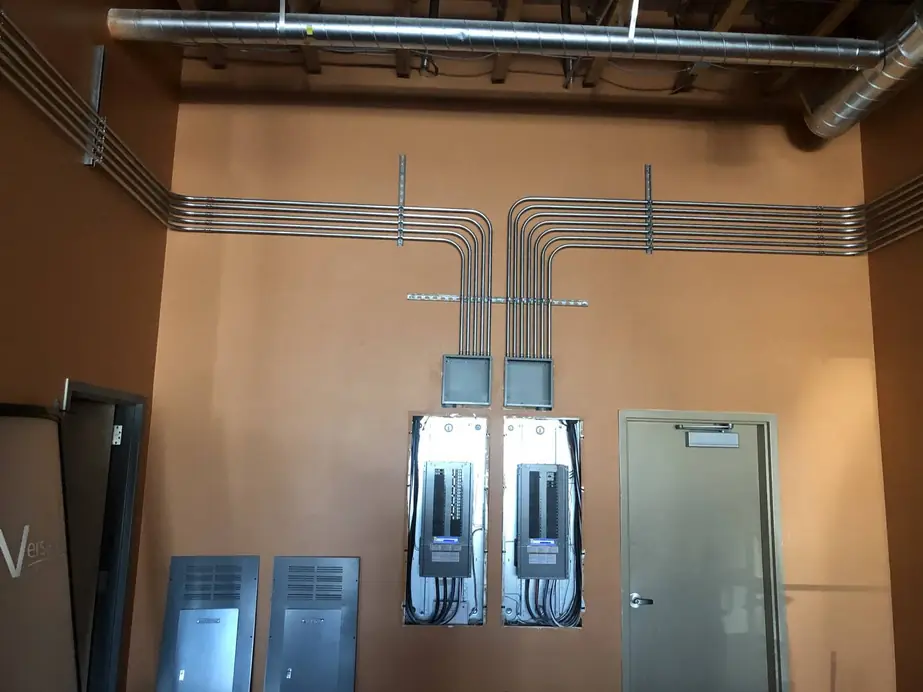 New commercial panels and conduit runs on a finished interior wall
