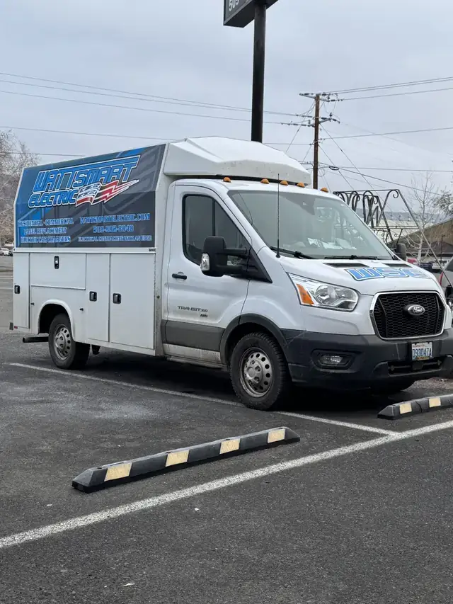 A Wattsmart Electric service van with the company wrap, parked in a lot